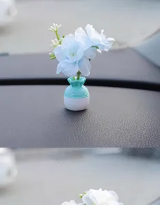Mini car artificial flower vase ornament detail view, creative dashboard micro decor.