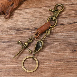 Detailed close-up of a vintage punk metal skull keychain with leather wrap and crossbones