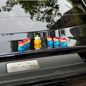 Detailed shot of cute mini dog figurines set, emperor and attendant resin toys for car decor.
