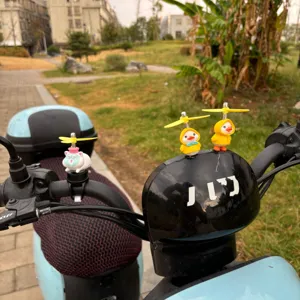 Vue de détail d'un jouet canard imperméable jaune avec hélice fixé sur le guidon.