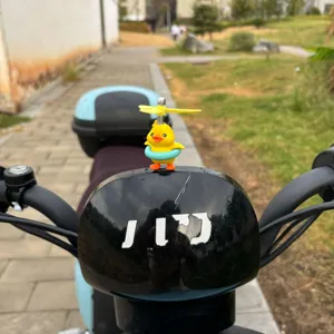 Gros plan détail du joli petit canard jaune avec hélice casque ornement sur guidon trottinette.