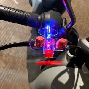 Dettaglio del giocattolo aereo luminoso alimentato a vento con luci LED per manubrio moto.