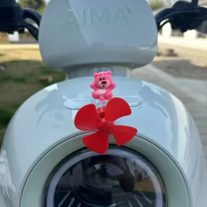 Primo piano di un grazioso ornamento a girandola con orsetto rosa per scooter elettrico.