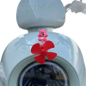 Dettaglio di ornamento per moto con orsetto rosa e ventola a elica rossa luminosa.