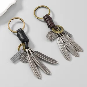 Retro hand-woven leather keychains featuring feather charms and engraved metal message tags