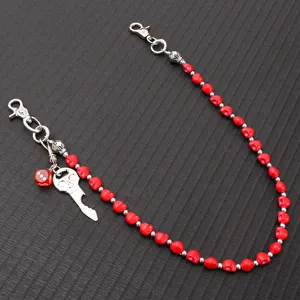 Close-up of punk hip-hop red skull pants chain with metal skull key and dice charms