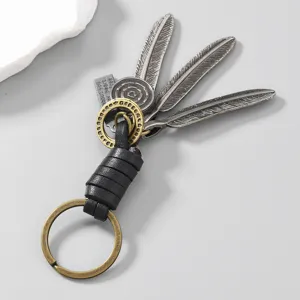 Detail view of retro handmade leather keychain with alloy feather charms and woven grip