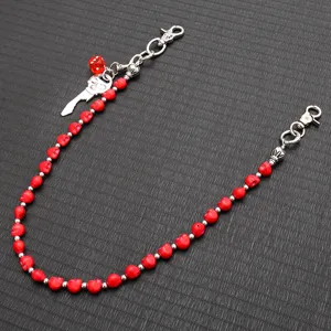 Detailed view of red skull bead wallet chain with silver metal hardware and charms