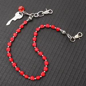 Detailed view of punk hip-hop waist chain featuring red skull beads and skull key charm