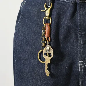 Détail d'un porte-clés punk vintage en laiton avec tête de mort sur un jean en denim foncé