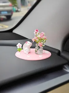 Joli ensemble de figurine de lapin et vase de fleurs sur le tableau de bord auto.
