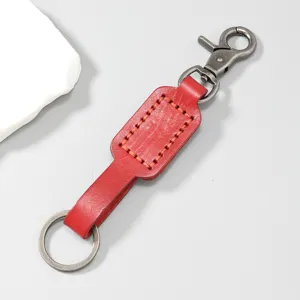 Detailed macro view of vintage red cowhide leather keychain with sturdy metal clasp