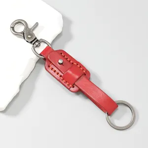 Detailed view of red genuine leather keychain featuring vintage metal hook and ring