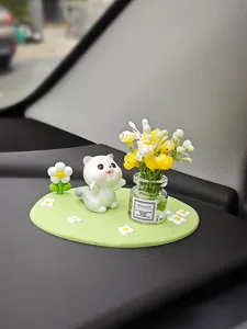 Détail de décoration de tableau de bord de voiture mignon avec figurine de chat et vase.