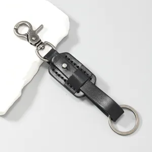 Close-up of vintage black cowhide leather keychain with antique metal hardware