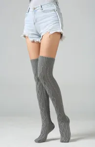 Grijs kabelgebreide over-the-knee beenwarmers detailopname met gestructureerd ruitpatroon.