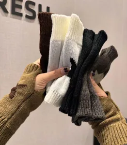 Detailed view of knitted fingerless warm gloves, winter wool star pattern cozy gloves.