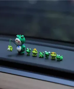 Detailed view of luminous little frog car dashboard ornaments, cute miniature desktop decor.