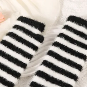 Close-up detail of black and white striped furry knit arm warmers, cozy winter sleeve cuffs.