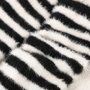 Close-up detailed view of fluffy black and white striped knitted cozy arm warmers.