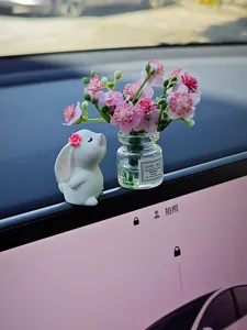 Jolie figurine de lapin avec mini vase en verre et fleurs artificielles roses pour tableau de bord.