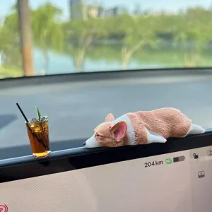 Vista dettagliata di una simpatica statuetta di corgi addormentato sul cruscotto auto.