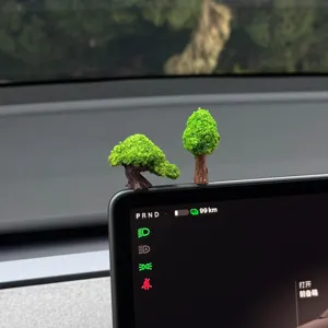 Miniature green tree ornament detail view for car interior dashboard decoration display.