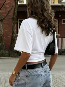 Detail view of stylish solid color short sleeve T-shirt paired with casual denim jeans.