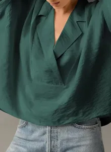 Detail view of a women's dark green satin-like blouse featuring a casual lapel collar design