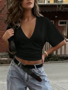 Detail shot of a black v-neck short sleeve top with flattering ruched waist design.