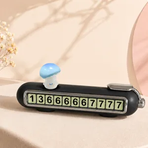 Dettaglio della simpatica carta parcheggio fungo blu, targa numero telefono auto nera.