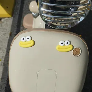 Close-up detail of cute monster eye mouth sticker decoration for electric scooter rear box.