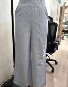 Détail du pantalon rayé bleu et blanc mettant en valeur la taille haute et le tombé.