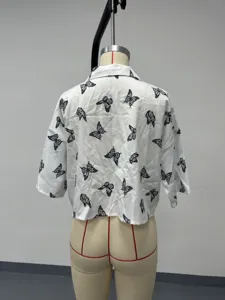 Vista trasera detallada de una camisa blanca de manga corta con estampado de mariposas.