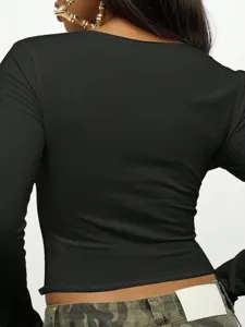Detailed back view of a black long sleeve crop top featuring a slim fit and cropped hem.