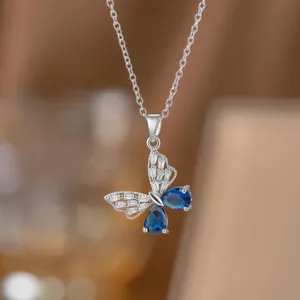 Detaillierte Nahaufnahme eines silbernen Schmetterlingsanhängers mit blauen Edelsteinflügeln