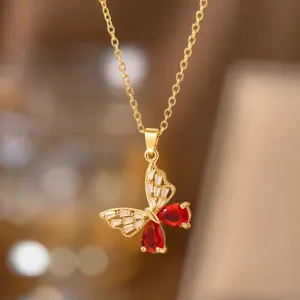 Nahaufnahme des goldenen Schmetterlingsanhängers mit roten und klaren Kristallen