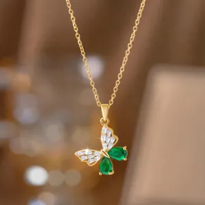 Detailansicht eines eleganten goldenen Schmetterlingsanhängers mit grünen Kristallen.