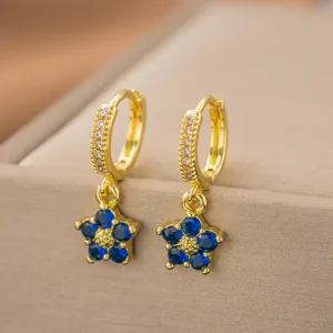 Detailansicht goldener Creolen mit wunderschönen blauen Edelsteinblumen-Anhängern
