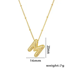 Detailaufnahme der vergoldeten Halskette mit M-Anhänger und Mikro-Pavé-Zirkonia-Besatz.