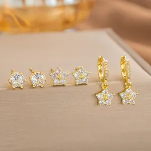Nahaufnahme von goldenen Blumen- und Zirkonia-Ohrringen auf dem Display