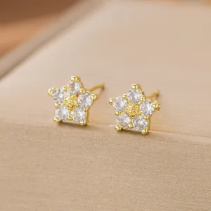 Nahaufnahme von goldenen Blumen-Ohrsteckern mit glitzernden Zirkonia-Steinen.