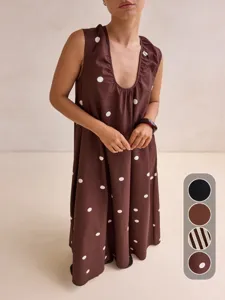 Detail view of the brown sleeveless polka dot long dress showing fabric texture and design.
