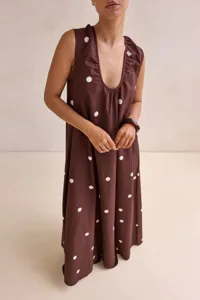 Elegant brown sleeveless maxi dress featuring classic white polka dots and a chic U-neck.