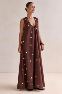 Detail view of the elegant brown polka dot sleeveless maxi dress showcasing the flowy drape.