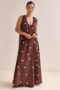 Detail view of the elegant brown sleeveless maxi dress featuring classic white polka dots.