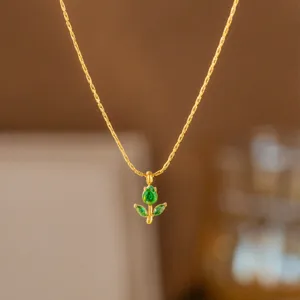 Detailaufnahme der goldenen Titanstahlkette mit grünem Zirkonia-Blumenanhänger