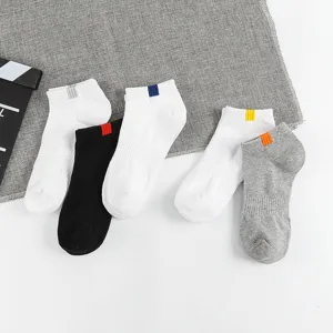 Detailed view of men's low-cut athletic boat socks in solid colors with colored heel tabs.