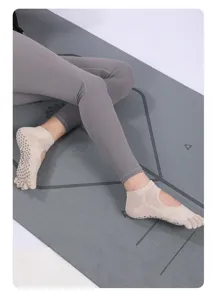 Detailed view of breathable five-toe yoga socks featuring open back and anti-slip grip soles.