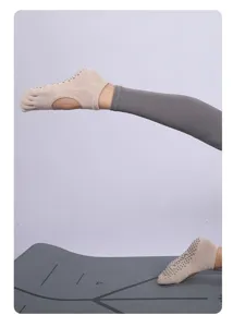 Detail shot of breathable beige five-toe yoga socks with open back and anti-slip grip dots.